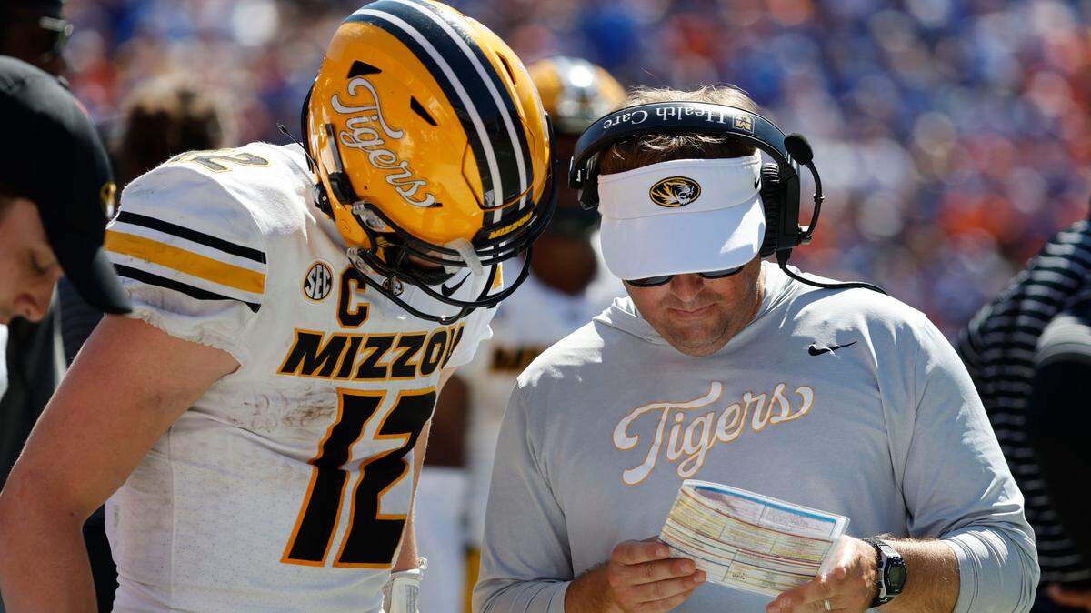 Missouri Tigers coach Eliah Drinkwitz and quarterback Brady Cook (12) talk during a game against the Florida Gators at Ben Hill Griffin Stadium on Oct. 8, 2022.