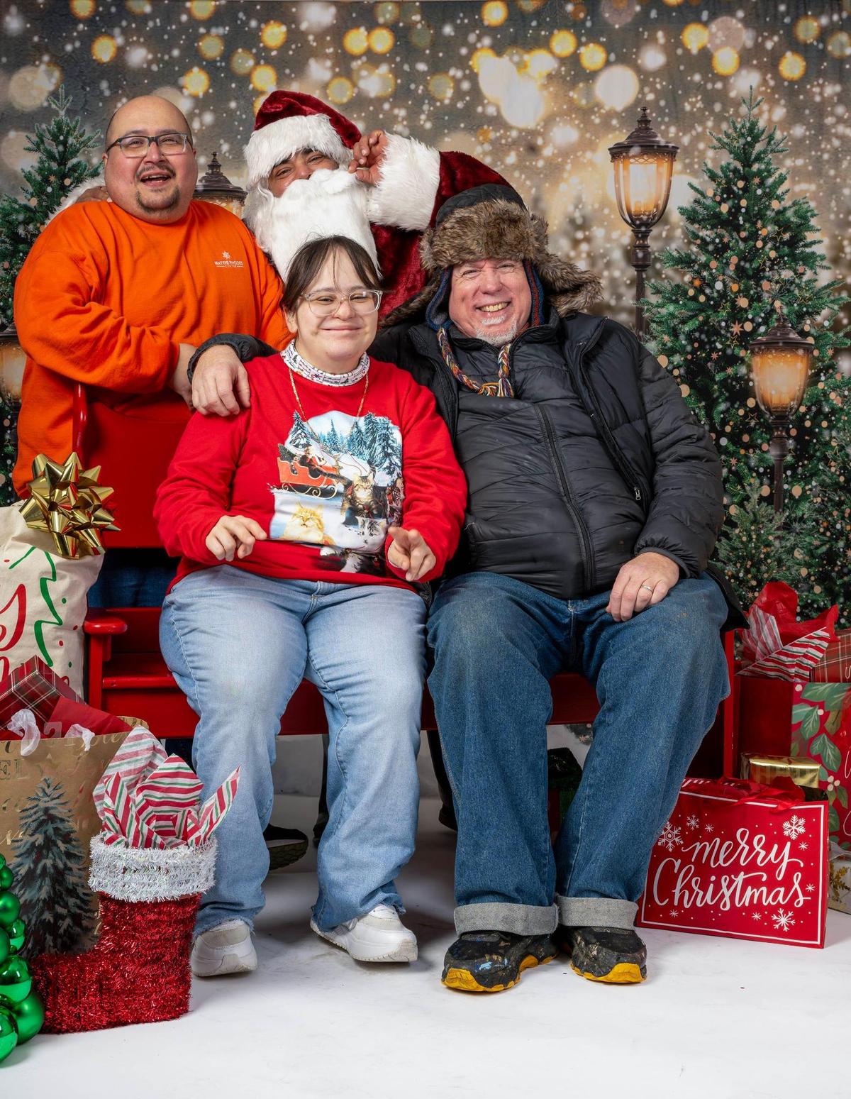 Anthony Rea, back row, left, Santa Claus, Talitha Castaneda, left front, and Gear Schweiger, right, sat for a photo at Mattie Rhodes Center Northeast on Saturday, Dec. 13, 2024 in Kansas City.