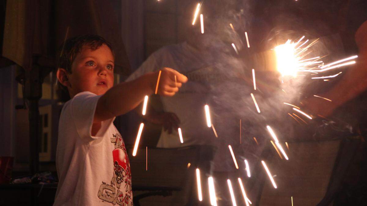 A child plays with a sparkler in this file photo. Six Kansas City-area grocery store chains have reduced hours on Independence Day 2024.