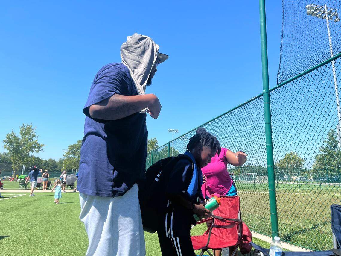 Orlando Strother and his son Noel cool off with cold towels and water after a soccer game at Compass Mineral Sporting Fields during a heat wave Sunday in Kansas City. Strother said his son enjoyed playing in the game despite the heat.