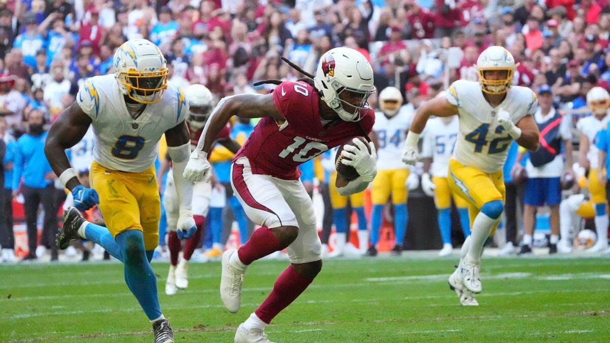 Arizona Cardinals wide receiver DeAndre Hopkins (10) runs away from Los Angeles Chargers linebackers Kenneth Murray Jr. (9) and Troy Reeder (42) before scoring a touchdown after a catch during the first quarter at State Farm Stadium in Glendale on Nov. 27, 2022.