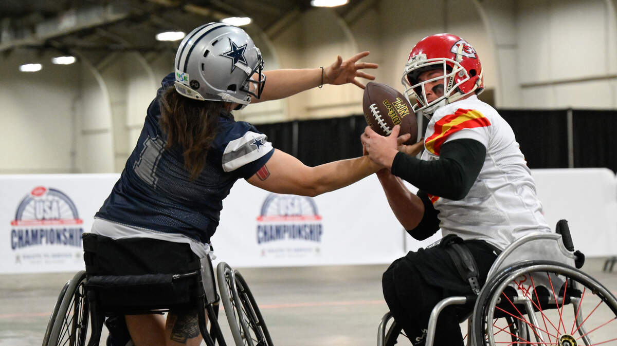 Kansas City Chiefs player Matt Bollig, right, fights for possession of a pass to Dallas Cowboys player Zach Blair, left, during the USA Wheelchair Football League Championship, a program of Move United, Tuesday, Feb. 6, 2024 in Dallas, Texas.