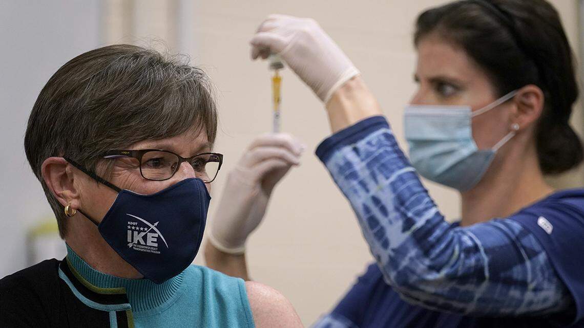 Public health nurse Lisa Horn prepares to give a COVID-19 vaccine injection to Kansas Gov. Laura Kelly Wednesday, Dec. 30, 2020, in Topeka.