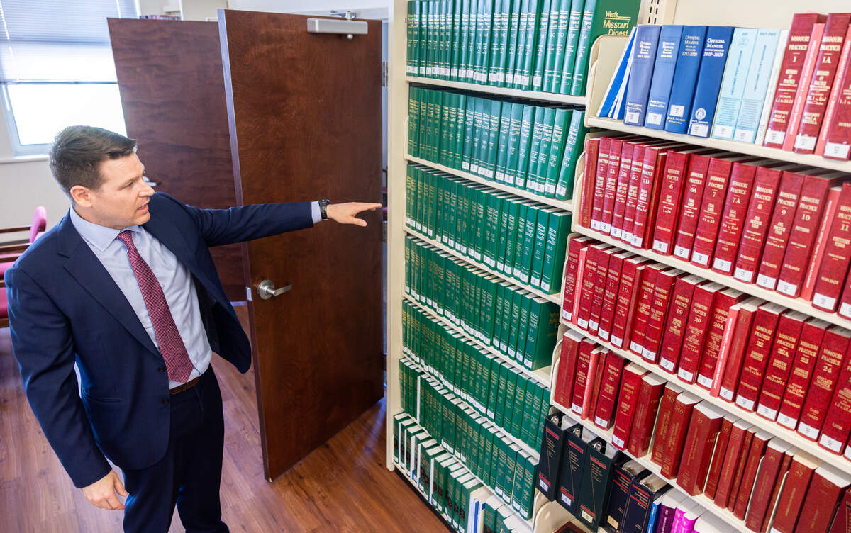 Shawn Lee, a Kansas City-based attorney, pages through a book in the Jackson County Law Library’s downtown Kansas City location. The location will close down as its lease expires at the end of May.