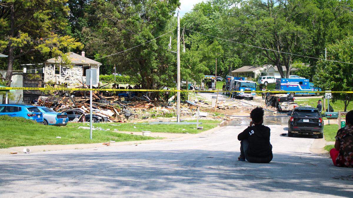 A neighbor looks on after a home explosion in Gladstone that left a man dead, his home destroyed and several others damaged Saturday, May 31.