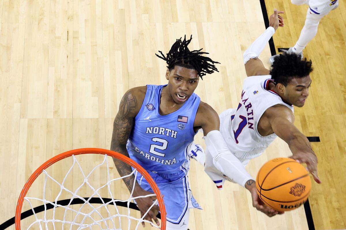 Caleb Love #2 of the North Carolina Tar Heels attempts a layup after getting around Remy Martin #11 of the Kansas Jayhawks during the second half of the 2022 NCAA Men's Basketball Tournament National Championship game at Caesars Superdome on April 04, 2022 in New Orleans, Louisiana.