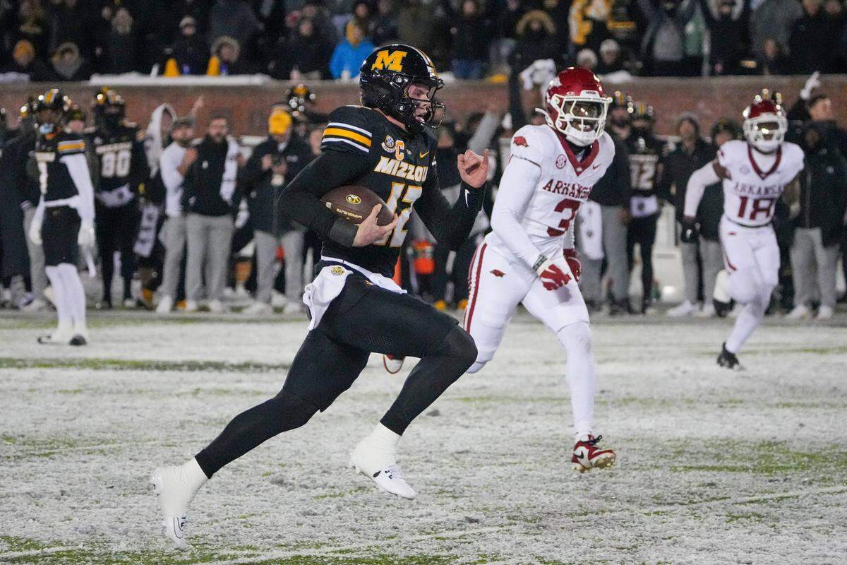 Missouri Tigers quarterback Brady Cook runs for the game-winning touchdown against the Arkansas Razorbacks in both teams’ regular-season college football finale at Faurot Field at Memorial Stadium in Columbia on Saturday, Nov 30, 2024.