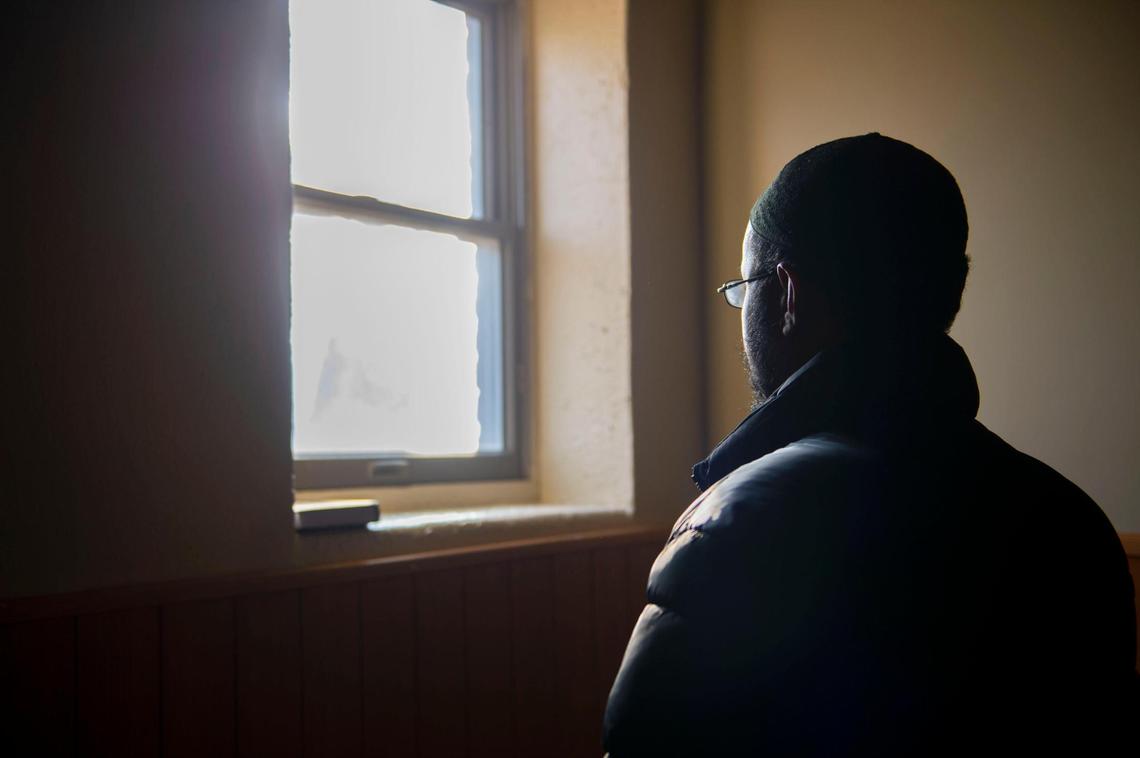 Abdinajib Dirir, one of the first Somali refugees to resettle in Kansas City, looks out of a window after Jummah prayer at Masjid Al-Huda on Friday, December 10, 2021. There were nearly 60 shootings in the mosque’s neighborhood in 2020.