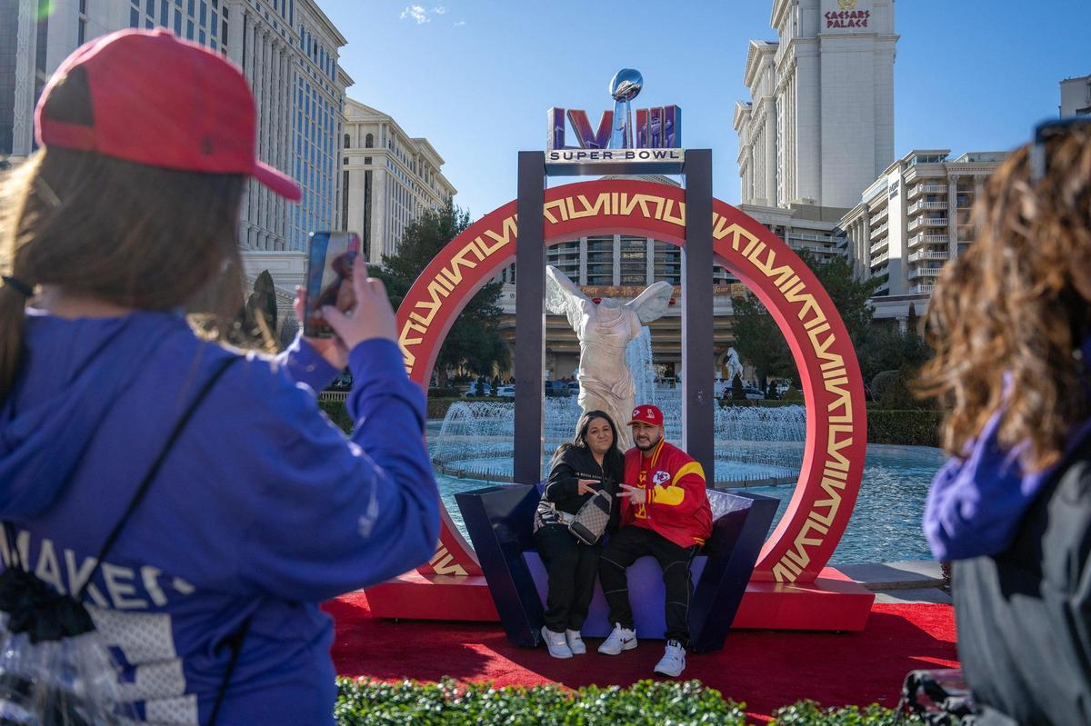 Christina Mitchell, left, and her husband, Mike, take photos under a Super Bowl LVIII-themed arch in front of the Caesars Palace Hotel and Casino on Saturday, Feb. 10, 2024, in Las Vegas.