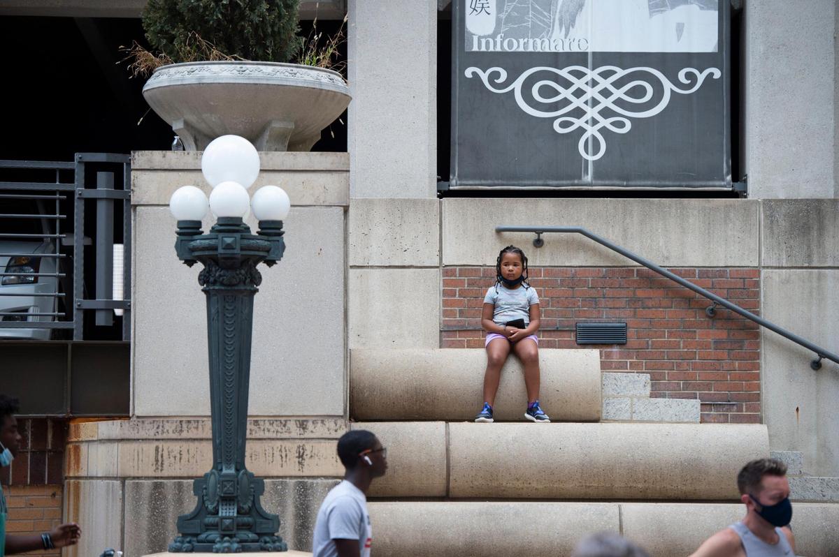 A young observer watched while volunteers worked to fill in giant outlined letters for the Black Lives Matter mural being painted on 10th St. Saturday between Wyandotte and Baltimore.