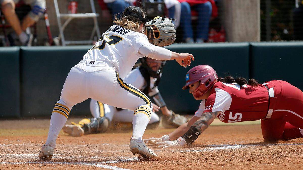 Oklahoma’s Haley Lee slides safely into home as Missouri’s Megan Schumacher awaits the throw during the fifth inning of the Tigers’ 11-0 loss to the Sooners on Saturday in Norman, Okla.