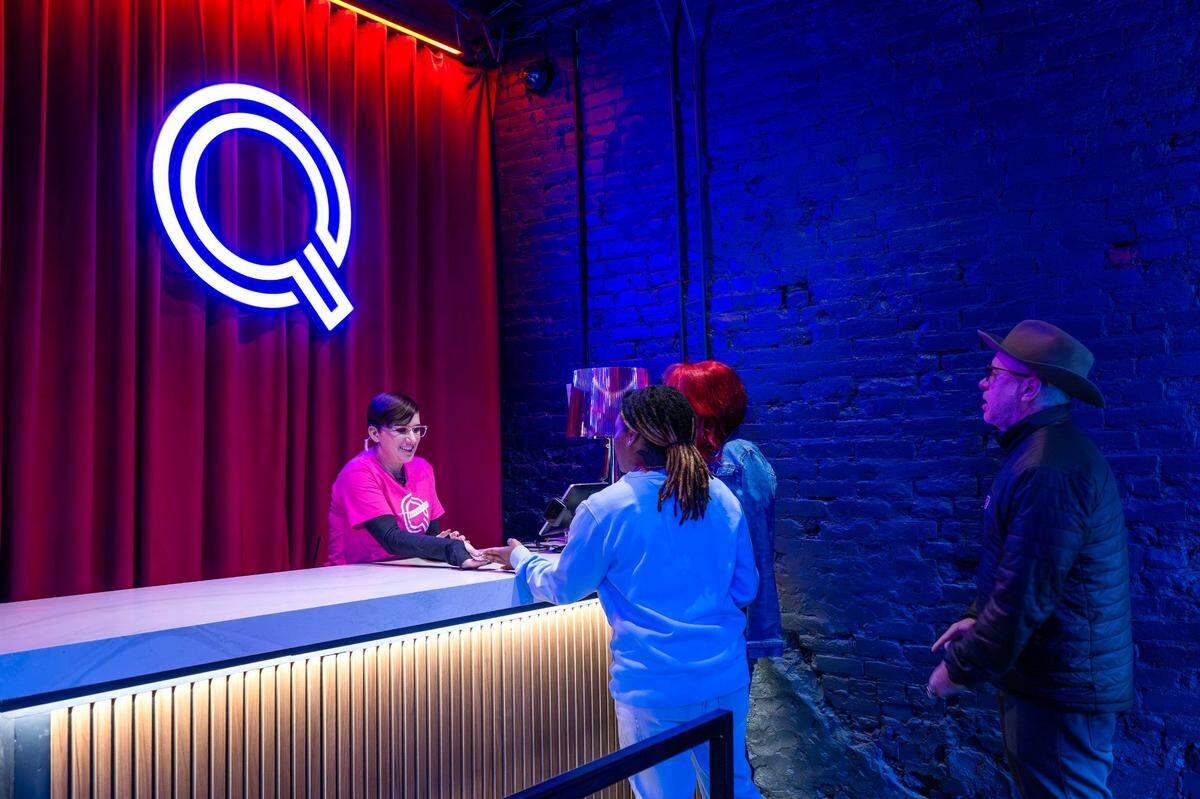 Kim Kielmann checks people in at the main entrance of Q Kansas City on Friday in Westport.
