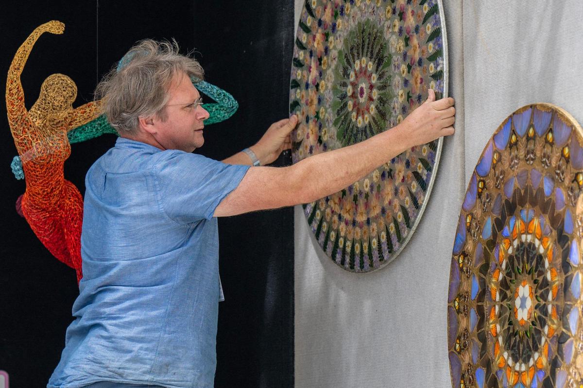 Michael Gard, from San Francisco, sets up his sculpture displays while preparing for the Brookside Art Annual.