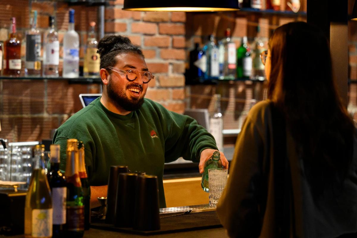 June Garcia, beverage manager, serves a patron at Green Dirt on Oak, a new restaurant with rooftop seating.