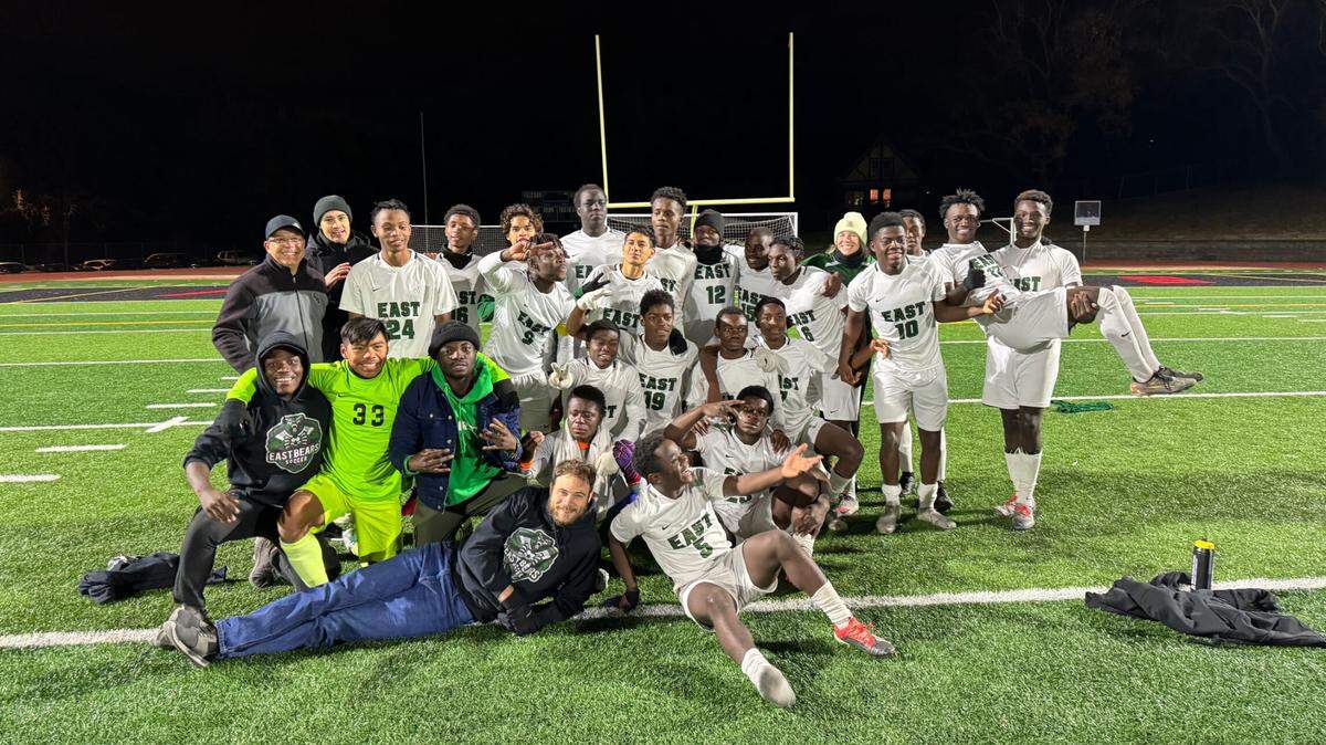 The East High School boys soccer team poses on the field.
