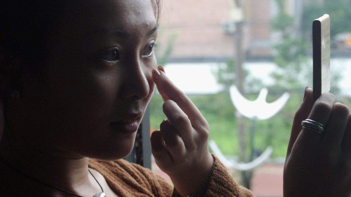 A woman putting on lotion.