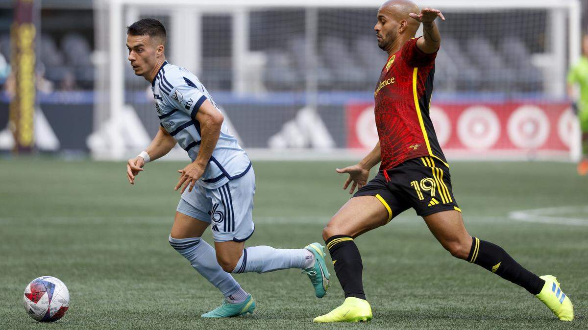 Sporting Kansas City midfielder Erik Thommy, left, dribbles against Sounders forward Heber during Sunday’s first half at Lumen Field in Seattle.