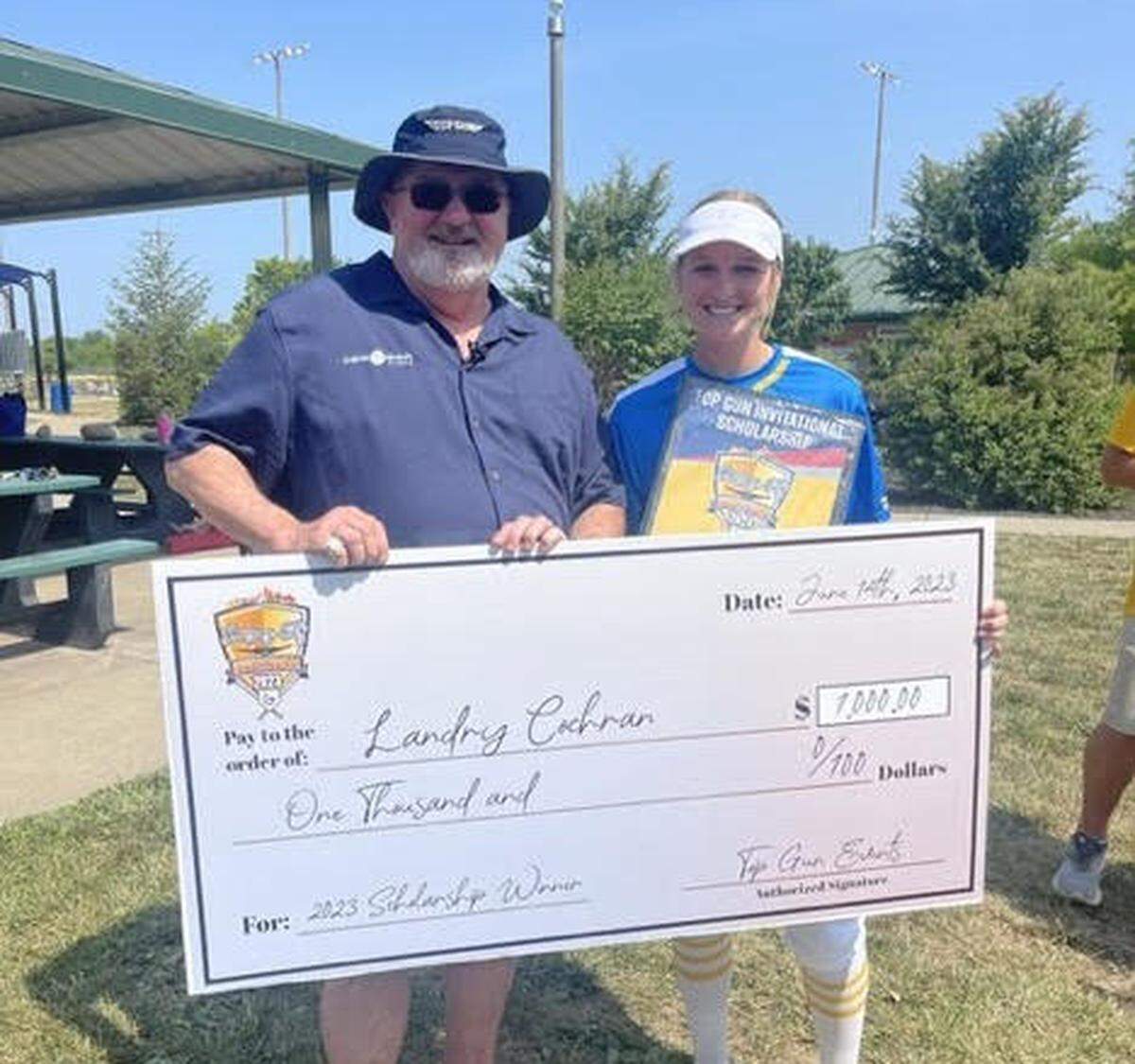 Scholarship winner Landry Cochran of the Missouri Chiefs stands with Top Gun Invitational founder Robb Behymer during the 2023 event in KC.
