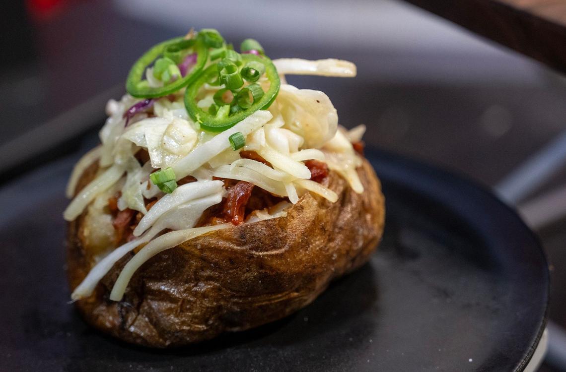 The Championship Hand Warmer, a baked potato served with barbecue pulled pork, fresh jalapenos and coleslaw, topped with Monterey Jack cheese and green onion, is a new offering from Aramark for the general concessions at GEHA Arrowhead Stadium. The new food items were announced Monday Aug. 26, 2025, at the stadium.