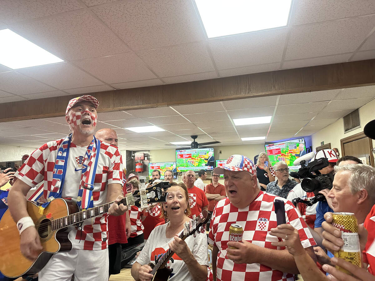 Mario Visković leads a song after the match ends, celebrating despite the loss to England.