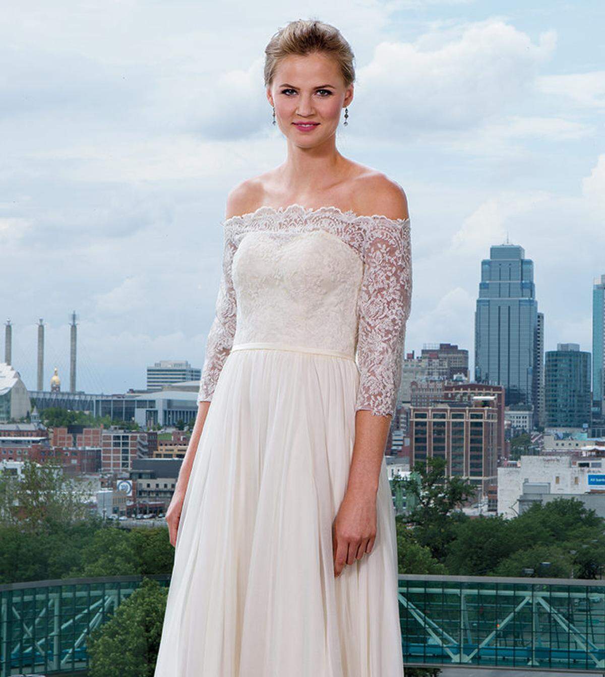A DAY TO REMEMBER Lace off-the-shoulder Emily Hart gown, $2,585, and drop earrings, $89, from Emily Hart Bridal.