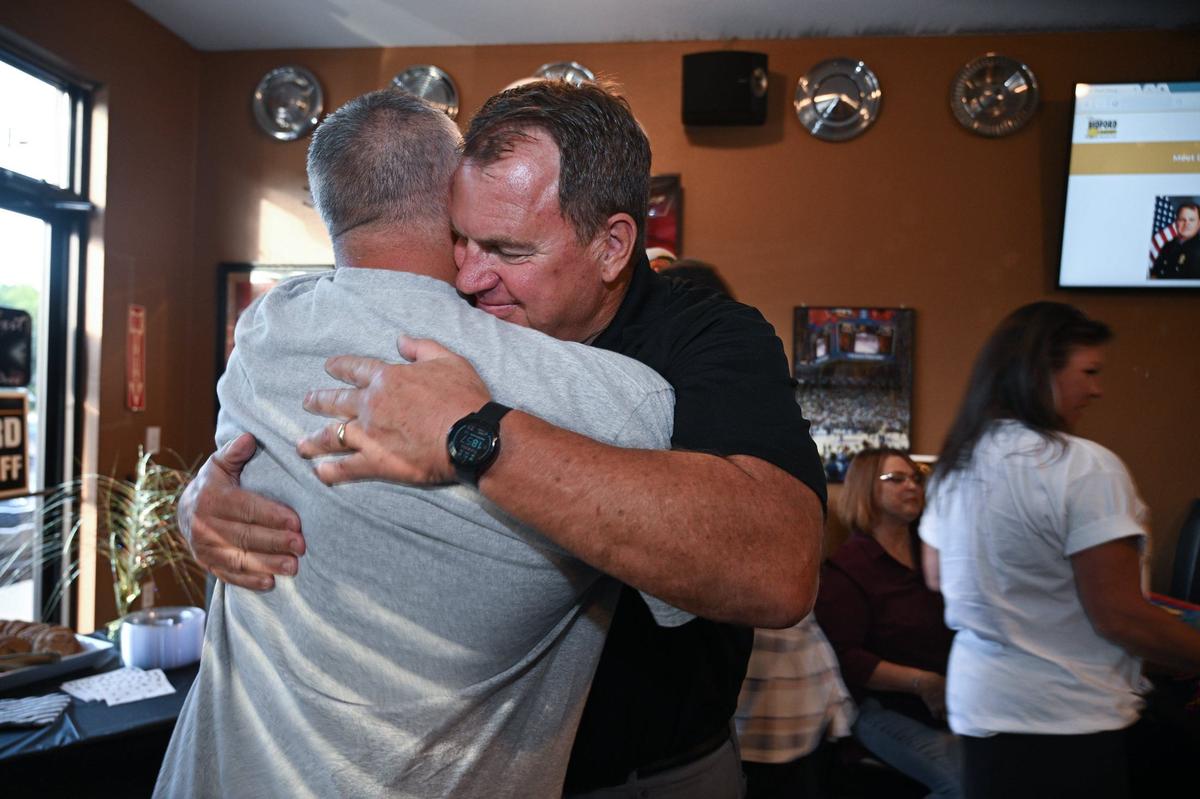 Doug Bedford, who won the Republican primary race for Johnson County sheriff, hugs Tom Reddin, a retired lieutenant, at an election watch party at JT’s Grill in De Soto. Reddin would become undersheriff if Bedford wins.