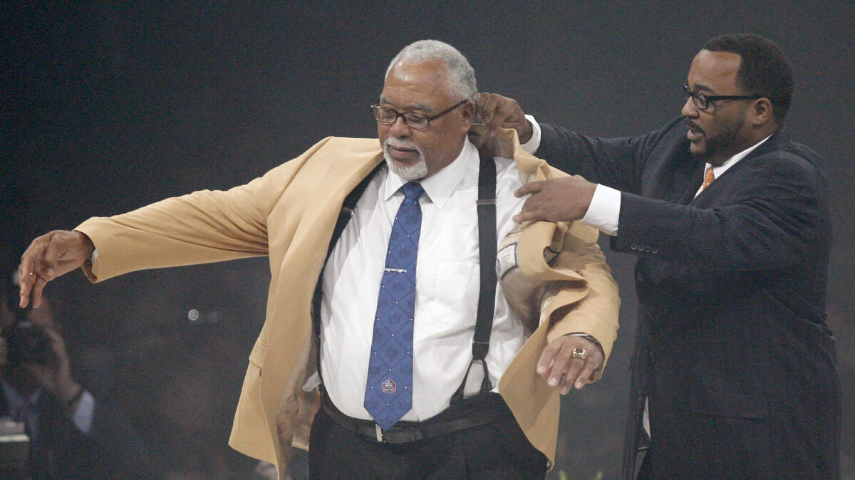 Curley Culp receives his symbolic gold jacket from his presenter and son Chad Culp, right, during the Enshrinees’ Gold Jacket Dinner at the Canton Memorial Civic Center Friday, Aug. 2, 2013 in Canton, OH. Culp will be enshrined into the Pro Football Hall of Fame Saturday. (AP Photo/The Repository, Scott Heckel)