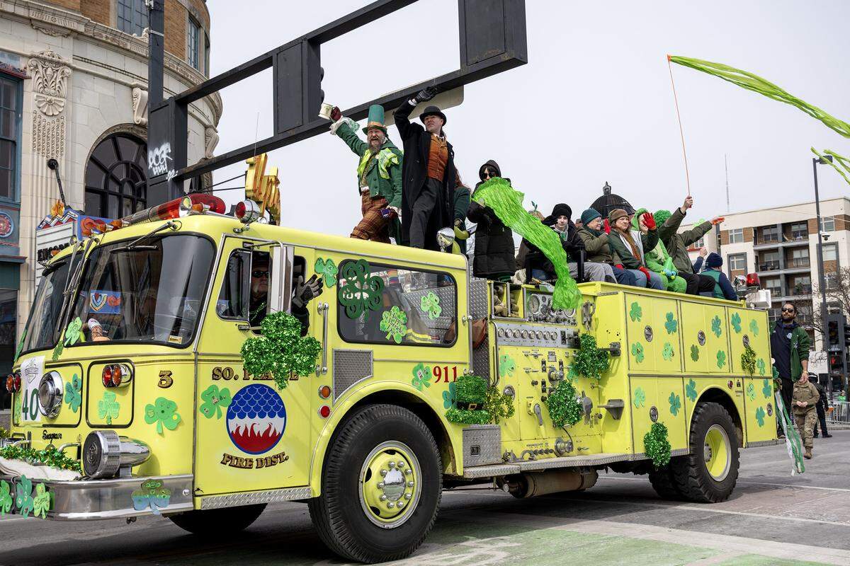 A lime-green fire truck travels along Broadway Boulevard during the St. Patrick's Day parade on Tuesday, March 17, 2026, in Kansas City.