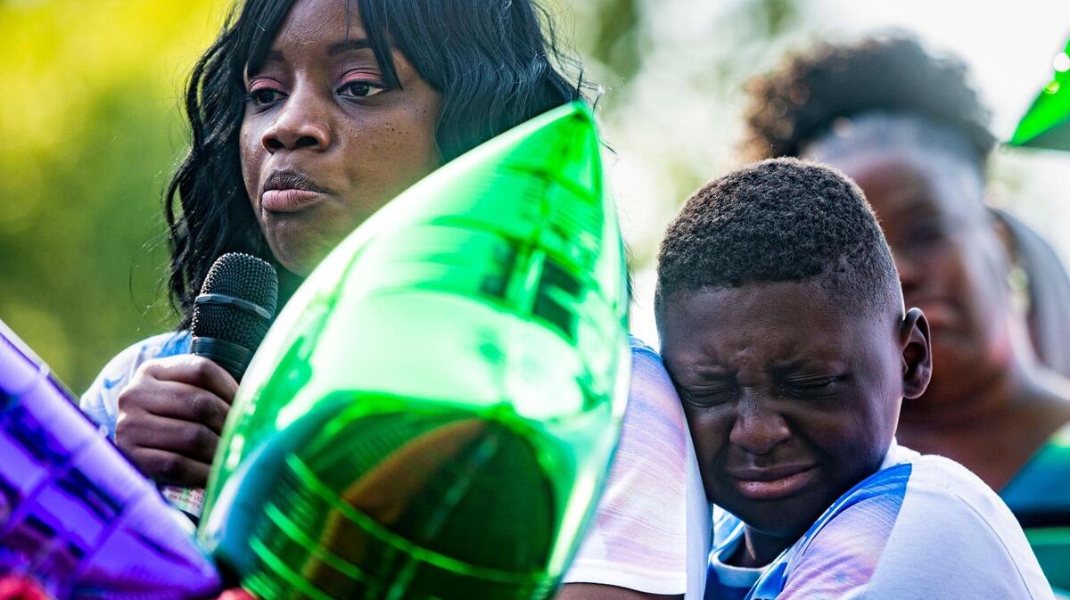 Michael Martin hugs his mother, Quiana Martin, as she speaks about the life of his grandmother Shirley Muhammad during the vigil to celebrate her life and the lives of Jaelin Ransom and Tyla Ransom, Thursday, July 29, 2021 at Stanford Brown Park in Kansas City. Friends and family gathered to let go of balloons and celebrate their loved ones lives.