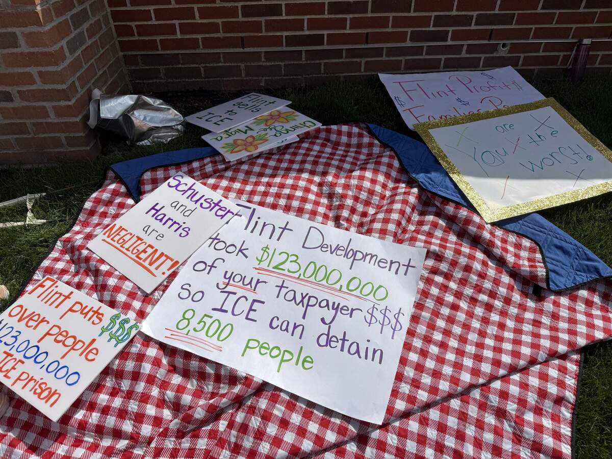 Signs seen at a protest against Flint Development on Monday, April 13.