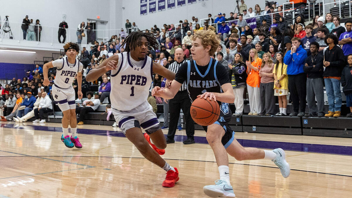 Oak Park’s Adam Tanner drives with Piper’s Derrick Jackson guarding at 810 Varsity Showcase 43, held Saturday, January 10, 2026, at Piper High School.