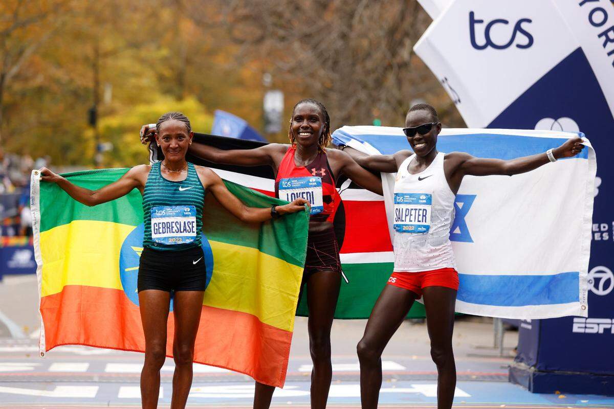 From left, women’s division third place finisher Gotytom Gebreslase, of Ethiopia, winner Sharon Lokedi, of Kenya, and second place finisher Lonah Chemtai Salpeter, of Israel, pose at the finish line of the New York City Marathon on Sunday.