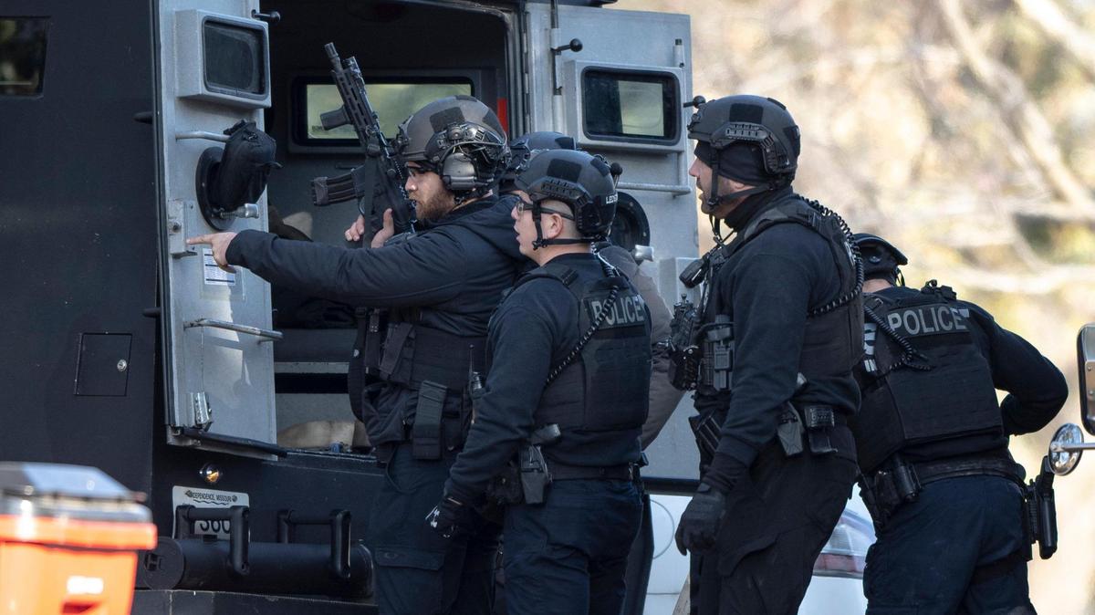 Independence SWAT team members strategize outside of a home where a man has reportedly barricaded himself inside with a baby on Wednesday, Nov. 16, 2022 in Independence, Mo.