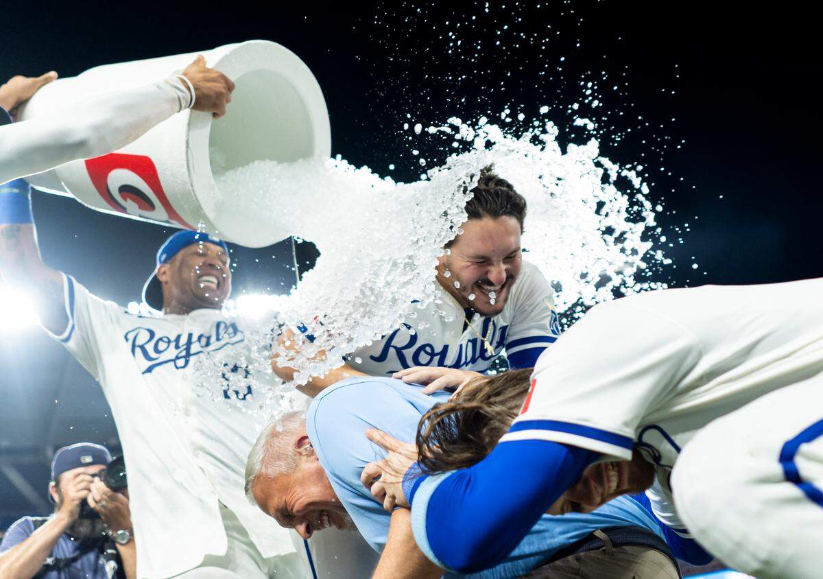 Kansas City Royals designated hitter Vinnie Pasquantino (9), shortstop Bobby Witt Jr. (7) and broadcaster Joel Goldberg are doused by first baseman Salvador Perez (13) and left fielder MJ Melendez (1) after defeating the Boston Red Sox at Kauffman Stadium on Aug. 7, 2024.