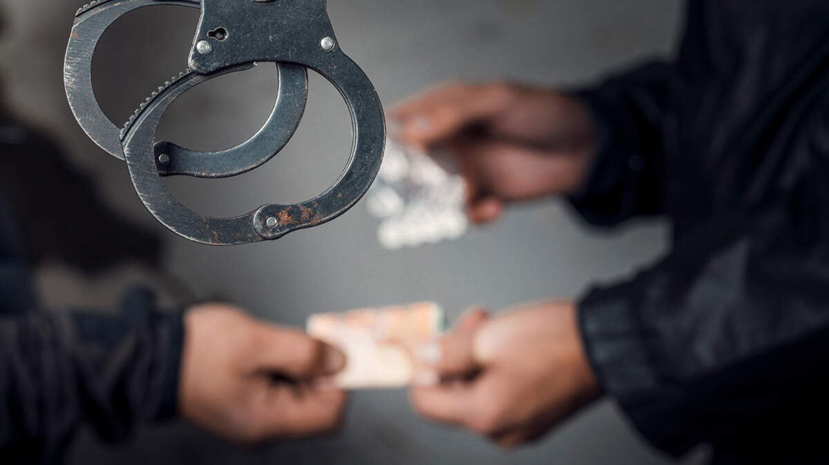 police officer and man arrested for drug possession. prison jail contraband staff guard handcuff narcotic