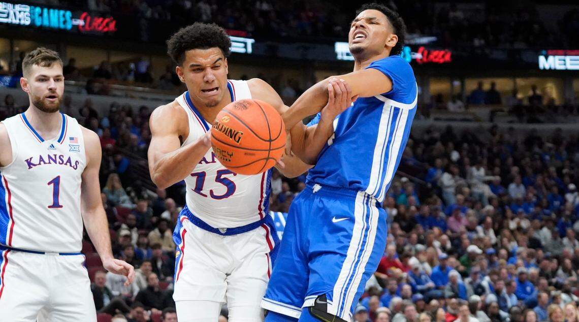 Kansas’ Kevin McCullar (No. 15) and Kentucky Wildcats forward Tre Mitchell battle for the ball during Tuesday night’s Champions Classic game at Chicago’s United Center.