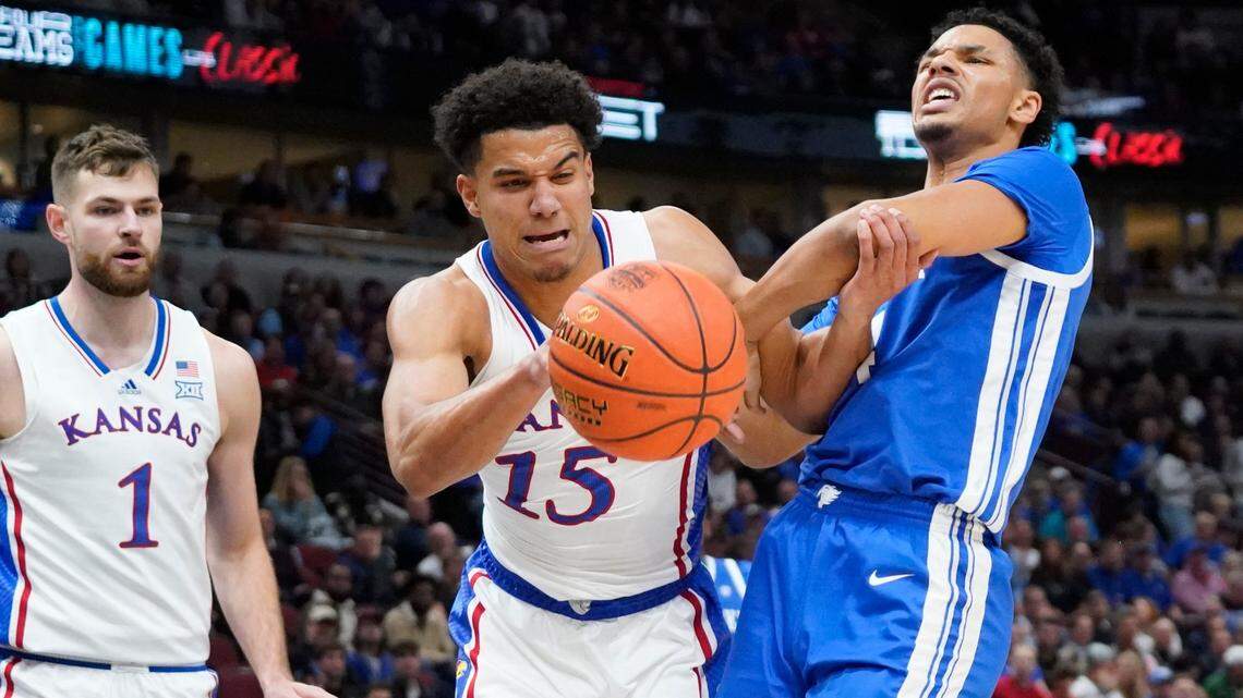 Kansas’ Kevin McCullar (No. 15) and Kentucky Wildcats forward Tre Mitchell battle for the ball during Tuesday night’s Champions Classic game at Chicago’s United Center.
