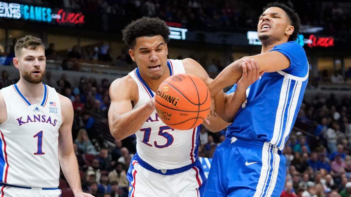Kansas’ Kevin McCullar (No. 15) and Kentucky Wildcats forward Tre Mitchell battle for the ball during Tuesday night’s Champions Classic game at Chicago’s United Center.