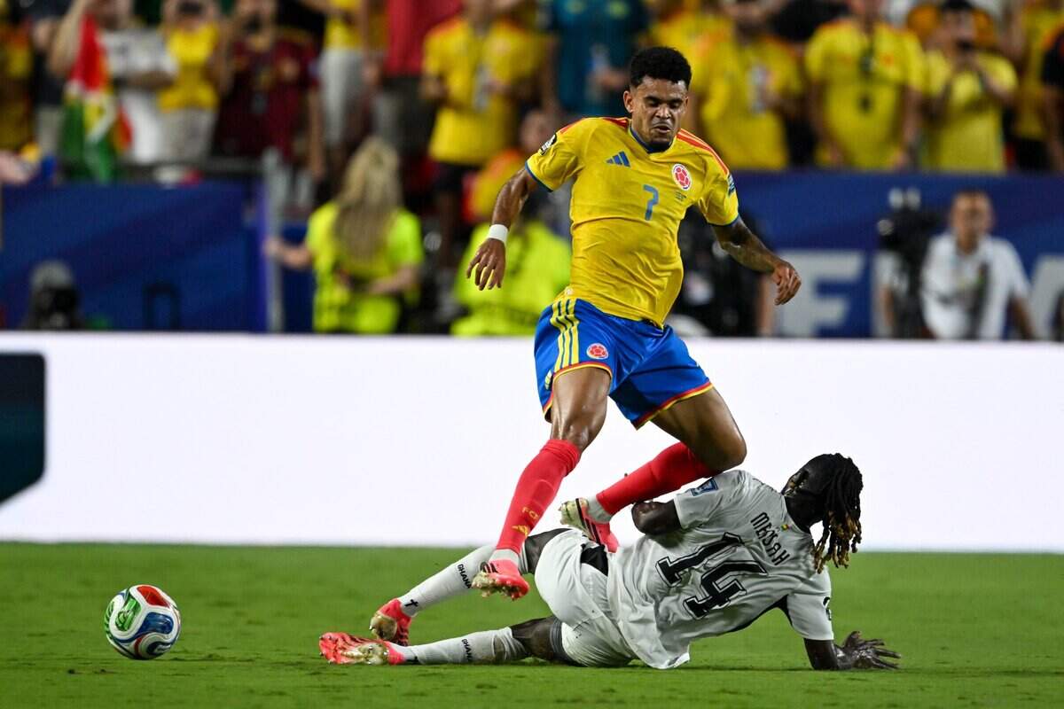 Colombia forward Luis Díaz (7) narrowly evades a tackle by Ghana defender Gideon Mensah (14) in the Colombia vs. Ghana 2026 World Cup Round of 32 football match at Kansas City (Arrowhead) Stadium in Kansas City on Friday, July 3, 2026.