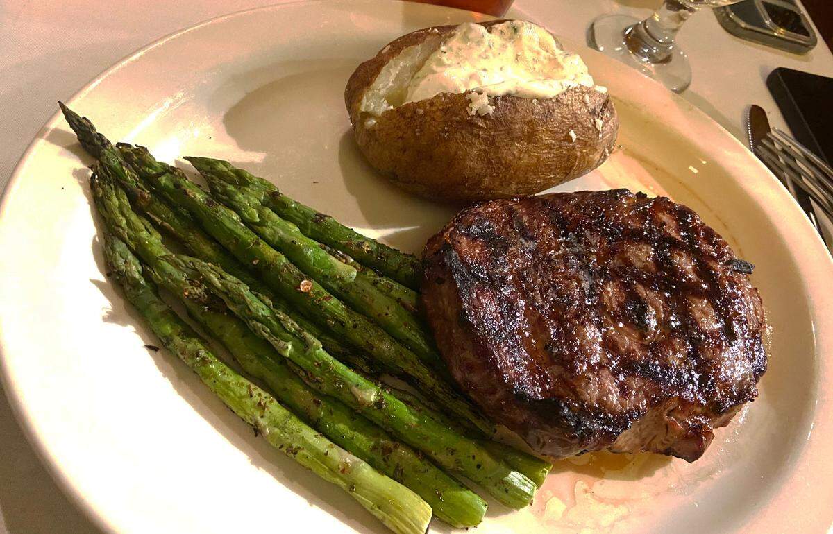 Piropos’ grilled ribeye ($51) is expertly cooked and well-seasoned. It’s served with asparagus and baked potato.