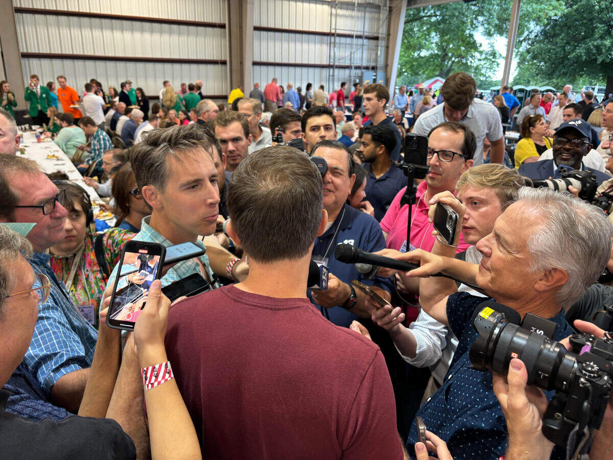 Josh Hawley and Lucas Kunce argue and answer questions amid a scrum of reporters at the Missouri State Fair on Thursday.
