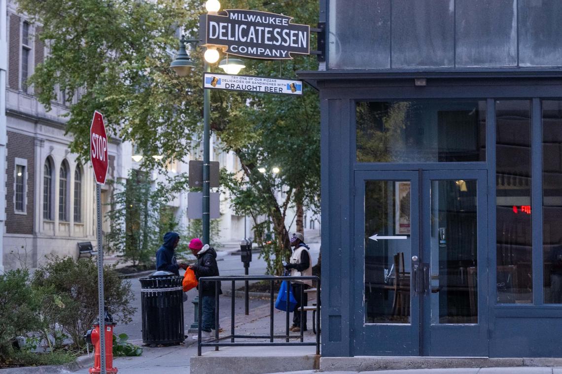 A small group of homeless people congregate near Milwaukee Delicatessen Company on a recent morning. Morning Glory Ministries, run by the Catholic Diocese of Kansas City-St. Joseph, relocated its breakfast program to the area 18 months ago. Members of the public have complained about the results.
