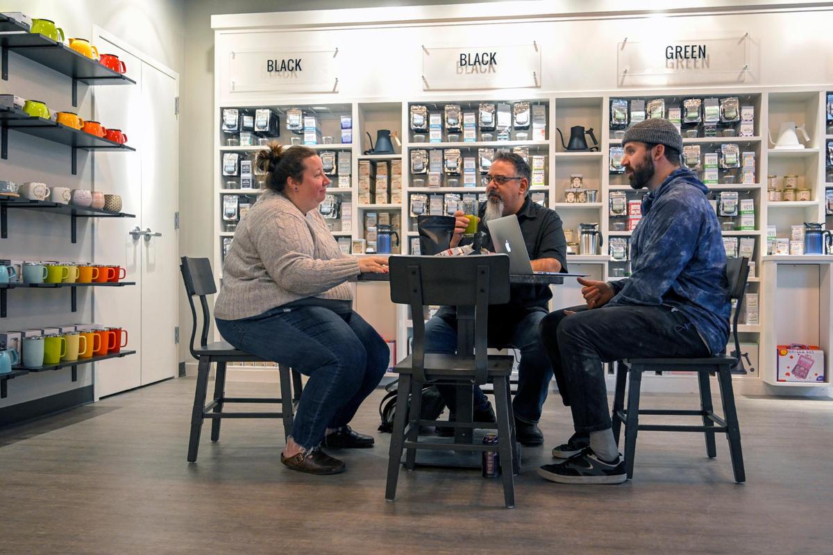 Savoy Tea Co. employees, from left, Stevie Gray, a store manager from Rogers, Arkansas, owner Bill Beyer, and Kyle Hansen, a wholesale worker, share a table at the new Savoy Tea Co., 2108 Wyandotte St.