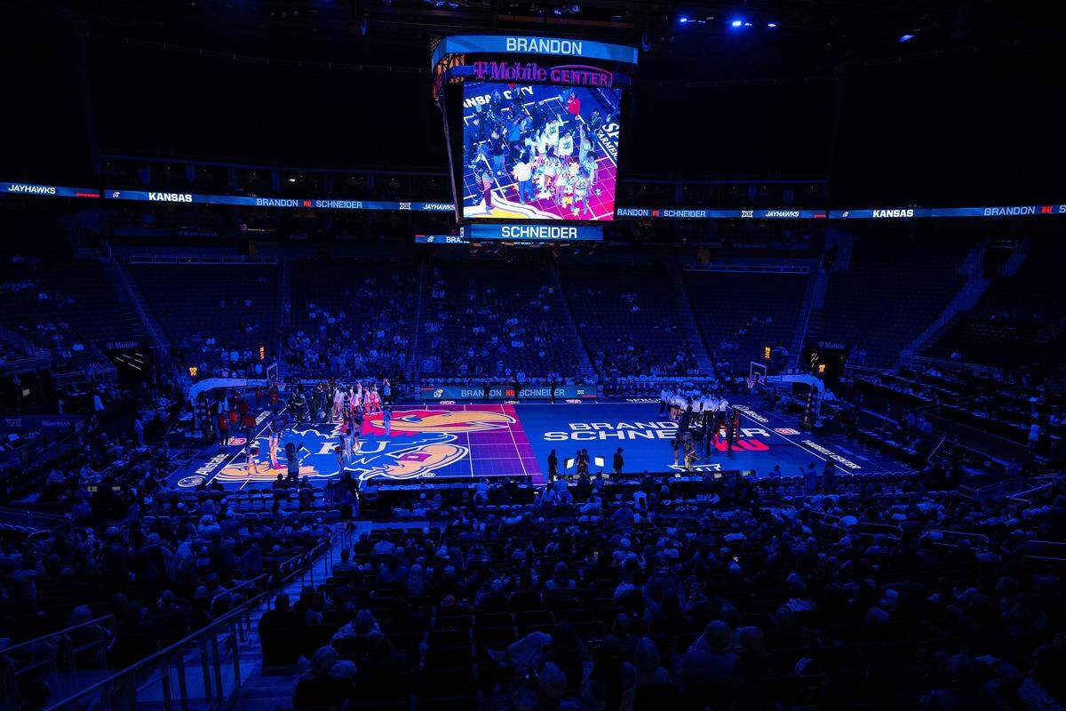 The basketball court lights up in a blue hue during Kansas Jayhawks player introductions before the Big 12 Women's Basketball Tournament at T-Mobile Center on Wednesday, March 4, 2026, in Kansas City.