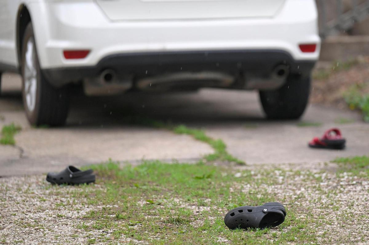 Shoes could be seen on the driveway of a home where three women were shot, one fatally, late Thursday, May 18, 2023, at this home in the 2700 block of North 123rd Street in Kansas City, Kansas. Police said a man suspected in the shooting was found dead inside the home.