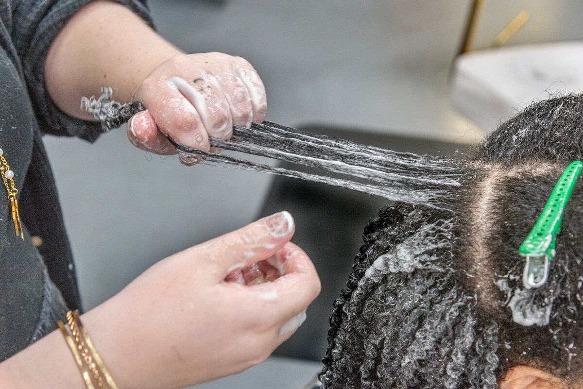 Salon owner Tippi Shorter Rank styles the hair of Vantania Pelzee at Hair Love KC.