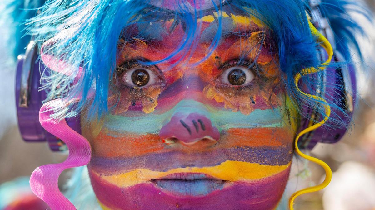 Ollie Clark, adorned in colorful face paint, stands for a portrait during the Krewe de Prank parade on Sunday, March 2, 2025, in Kansas City.