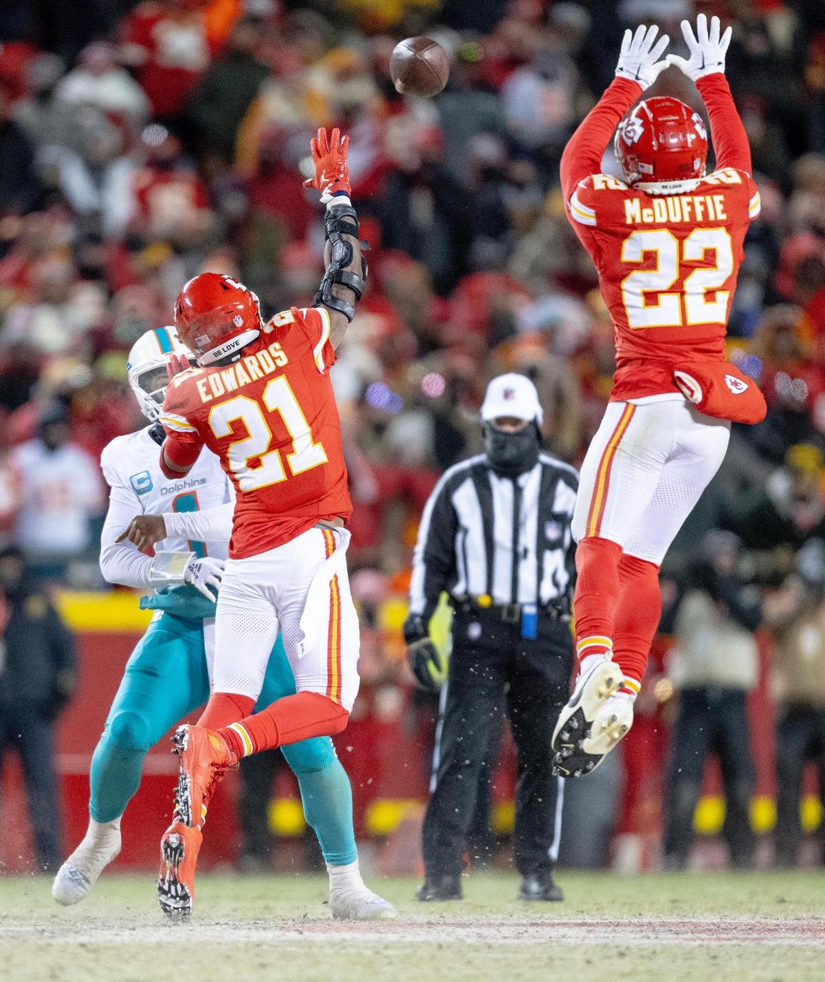 Kansas City Chiefs safety Mike Edwards (21) and cornerback Trent McDuffie (22) pressure Miami Dolphins quarterback Tua Tagovailoa (1) during an AFC Wild Card game at GEHA Field at Arrowhead Stadium on Saturday, Jan. 13, 2024, in Kansas City.