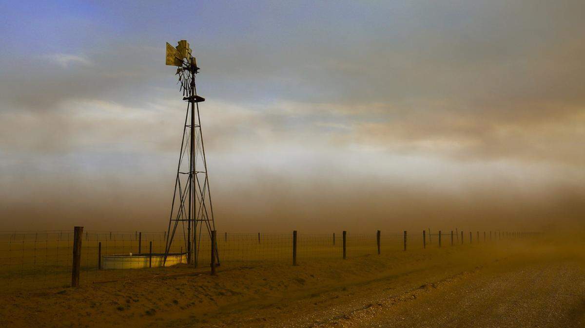 An image reminiscent of the “Dust Bowl” era,  fierce winds whip of clouds of dust as top soil is stripped from the land burned by prairie fires near Deerhead, Kan., in April 2016. Deerhead is nothing more than a crossroad in south central Kansas.  Established in 1885, the town disappeared for good in 1923.