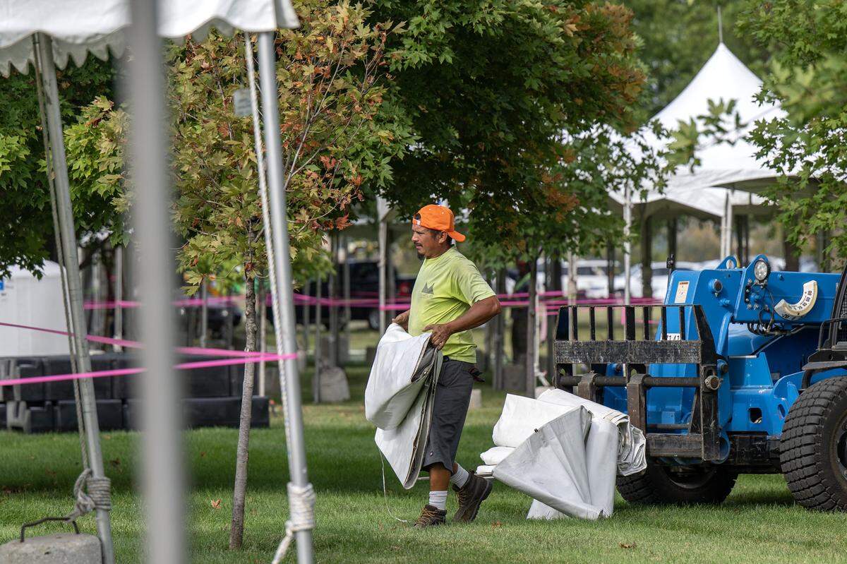 An event staffer arranges tarps while setting up tents outside the National WWI Museum and Memorial on Tuesday, Sept. 30, 2025, in Kansas City, ahead of pop singer Chappell Roan's concert Visions of Damsels and Other Dangerous Things.